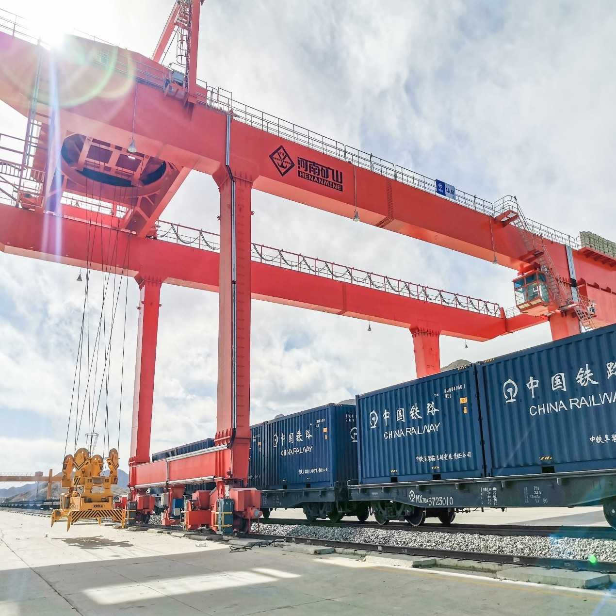 Gantry crane handling freight at a railway yard